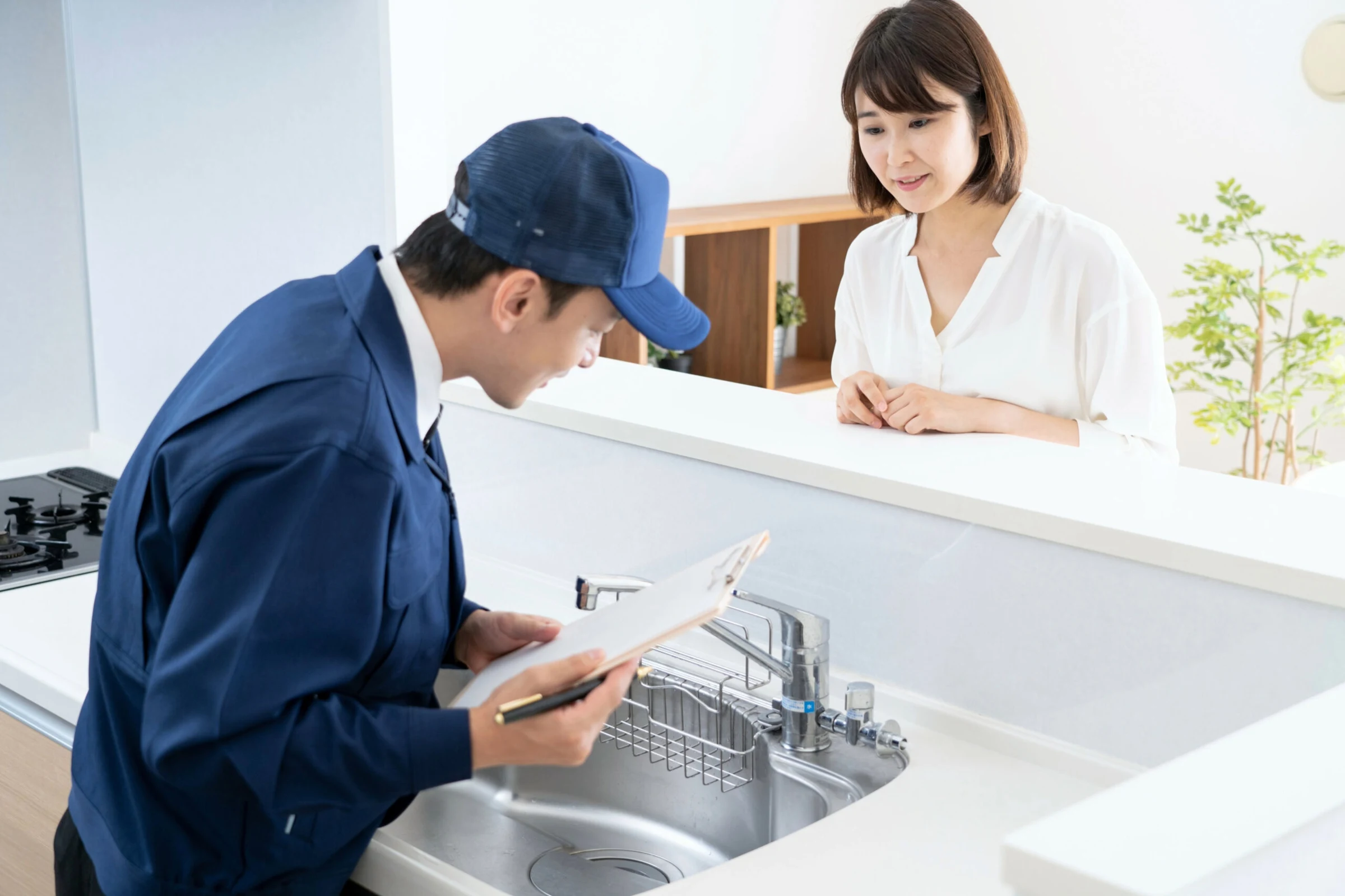 キッチンの水まわりについて相談を受ける作業員
